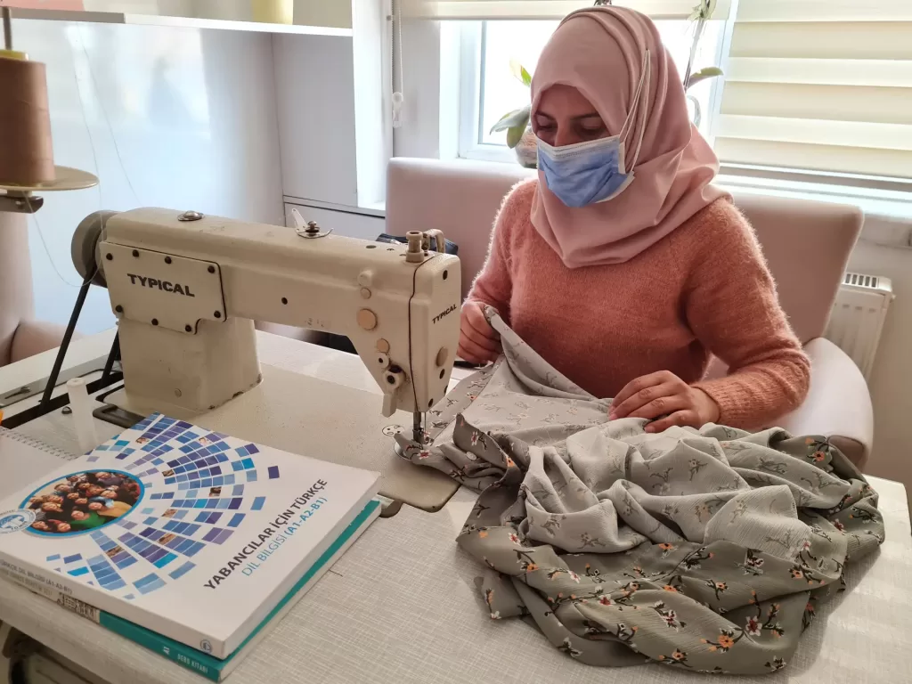 Ragda, Suriye’deki iç savaş sonrası Türkiye’ye sığındı. Şimdi burada hem terzilik yapıyor, hem de fen bilgisi öğretmenliği okuyor. Ragda’nın zorluklar karşısındaki güçlü tavrı ve duruşu, bugün artık başka çocuklara ve gençlere örnek oluyor, ilham veriyor. UNICEF ortaklığında çalışmalarını sürdüren Sığınmacılar ve Göçmenlerle Dayanışma Derneği (SGDD-ASAM) Ankara Al Farah Çocuk ve Aile Destek Merkezi’nde sığınmacılara yönelik düzenlenen “rol model eğitimleri”nde Ragda deneyimlerini aktarıyor ve bir “rol model” olarak başarı hikayesini paylaşıyor. Erken yaşta evlilik, eğitimin önemi, özellikle kız çocuklarının okullaşması ve toplumsal cinsiyet eşitliği gibi konularda yararlanıcıları bilgilendiren Ragda, ilham almaları için ailelere kendi hikayesini anlatıyor. “Biz fakir bir ailenin çocuklarıyız. Babamız vefat etmişti. Annem artık çok yorulmuştu. Altısı kız yedi çocuğun sorumluluğunu üstleniyordu. O yüzden ‘okulunuza biraz ara verin. Bana evi geçindirmekte yardımcı olun’ deyince, çok sevmeme rağmen okulu bıraktım. Okumayı çocukluğumdan beri çok severdim, evdeyken her fırsatta kitap okurdum. Hayat şartları okulu bırakmamı gerektirdi ama eğitimime bir şekilde devam etmek konusunda aslında kararlıydım” diye anlatıyor hikayesini Ragda. Okulu bıraktıktan sonra on yıl ara verdiğini ve sonrasında liseye 9. sınıftan tekrar döndüğünü belirten Ragda, savaş nedeniyle 2013 sonunda Türkiye’ye geldiğinde 34 yaşında olduğunu ve gelmeden önce Suriye’de terzilik yaptığını söylüyor. Türkiye’ye geldiğinde arkadaşlarından Yabancı Öğrenci Sınavı’nı duymuş ve yıllardır hayalini kurduğu üniversite eğitimi için şansını denemek istemiş. Ailesi Ragda’ya hem okumak hem çalışmak zor olabilir demesine rağmen o vazgeçmemiş. Şimdi, bir yandan bir terzi atölyesinde kadın kıyafetleri dikiyor, bir yandan da Uşak Üniversitesi’nde fen bilgisi öğretmenliği okuyor. Annesinin en büyük destekçisi olduğunu kaydeden Ragda, “Okulumu bitirdikten sonra kadın ve kadın sorunları alanında öğrenimime devam etmek istiyorum. Suriye’deyken savaş öncesi kadın hakları konusunda bilgimiz vardı ama Türkiye’de kadınların haklarından daha çok haberdar olduğunu görüyorum. Türkiye’deki sığınmacı kadınların da eğitim alması destekleniyor. Bana göre bir kadının en önemli hakkı eğitim. Kendime güvenimi arttırdı burada öğrendiklerim. Vatanıma daha güçlü dönebileceğime dair bir umut verdi” diyor. Rol model seminerlerine yoğun ilgi olduğunu belirten Ragda, “Gelecek bence kadınlar sayesinde şekillenecek. Kadınlar zayıf, güçsüz ve korunmaya muhtaç bir şekilde kalmayacaklar. Kendi ayakları üstünde duran, güçlü, hakkını arayan ve alan, kendini sürekli geliştiren bireyler olacaklar. Ben de Al Farah’taki etkinliklerde bunları görüyorum” diyor. UNICEF ortaklığında çalışmalarını yürüten SGDD-ASAM Ankara Al Farah Çocuk ve Aile Destek Merkezi Program Asistanı Duygu Yılmaz, merkezde sığınmacılara sosyal, sağlık, hukuk gibi birçok alanda danışmanlık verdiklerini belirterek, “çocuklar için yaşam becerilerini geliştirme ve psiko-sosyal destek sağlamaya çalışırken, yetişkinlere yönelik “güçlendirme ve farkındalık artırma” konusunda çeşitli eğitimler ve atölyeler düzenliyoruz. Rol Model Eğitimi de bunlardan biri” diyor. Etkinlikle sığınmacıların, rol model olarak deneyimlerini paylaşan kişilerin yaşam öyküsünden yola çıkarak kendi hayatlarına dönük farkındalığın arttırılmasını amaçladıklarını anlatan Yılmaz, “Konular özellikle kız çocuklarının okullaştırılması dolayısıyla erken yaşta evliliklerin önüne geçilmesi temelinde işleniyor. Rol modelimiz Ragda Elukla, eğitime oldukça önem veren, birçok engeli aşıp eğitim hayatına devam eden bir yararlanıcımız. Onun yaşam hikayesi, eğitime devam etme noktasında birçok ebeveyne ve kız çocuğuna ilham oluyor, yol gösteriyor. Her hafta farklı yararlanıcılarla psikoloğumuzun da eşlik ettiği görüşmeler gerçekleştirip, eğitimin önemine değiniyoruz. Katılımcıların yaşamış olduğu zorlukların ve bu zorlukları aşarken nelerden güç aldıklarının da paylaşıldığı, aktif katılımın gerçekleştiği oturumlara olan talep günden güne artıyor” dedi.